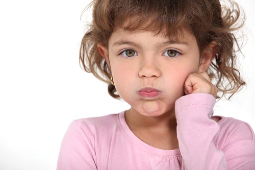 Child holding her breath with cheeks puffed out
